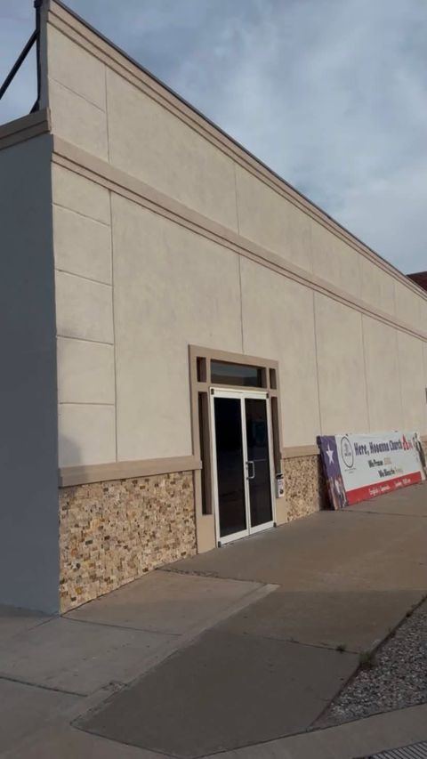 After: the remodeled front with smooth cream walls, stone trim, new glass doors and a Hosanna Church banner.