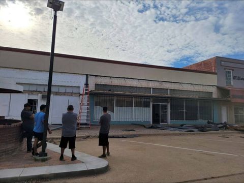 Before: the building's old storefront with a damaged awning and torn materials on the ground, as church members look on.